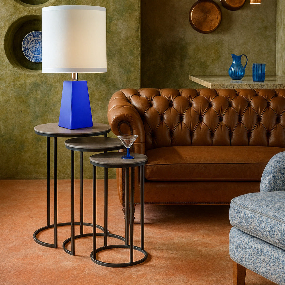 Living room with brown leather sofa, blue lamp, and decorative items on a green wall.
