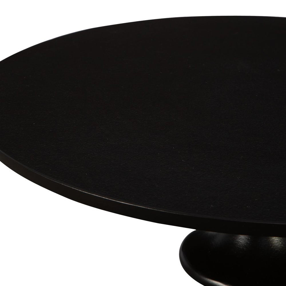 Table surface of round black metal accent table.