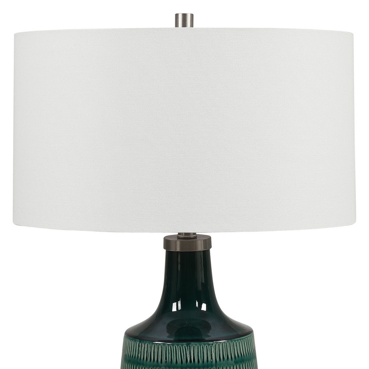 Table lamp with a green base and white shade on a white background