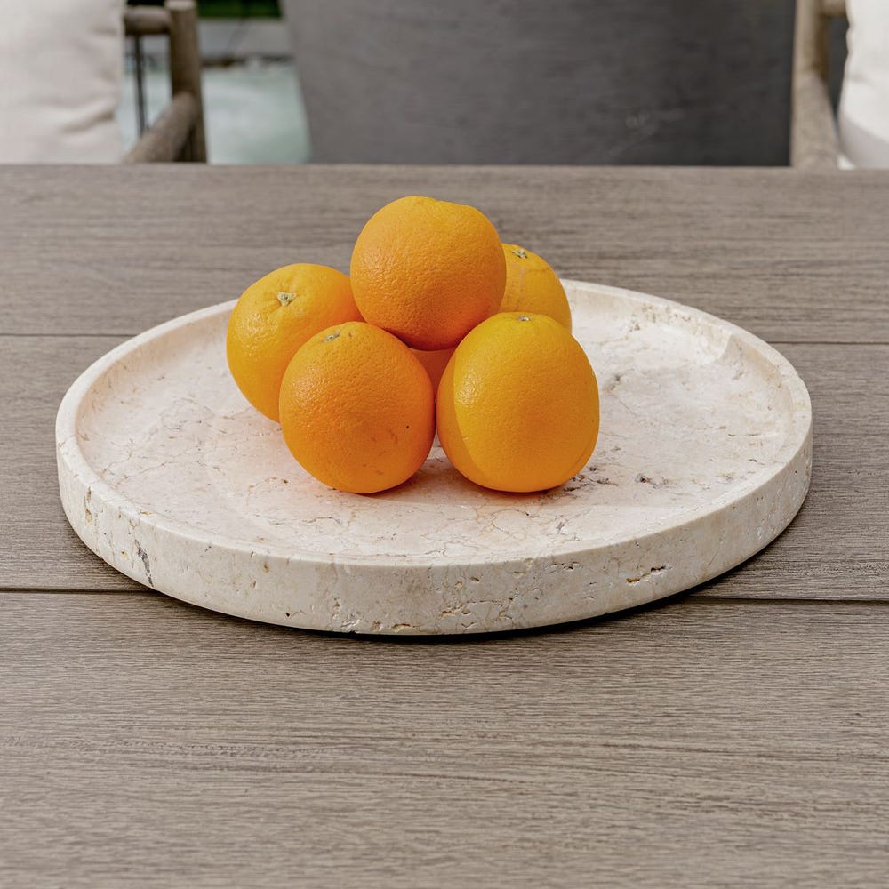 Oranges on a travertine tray on a wooden table