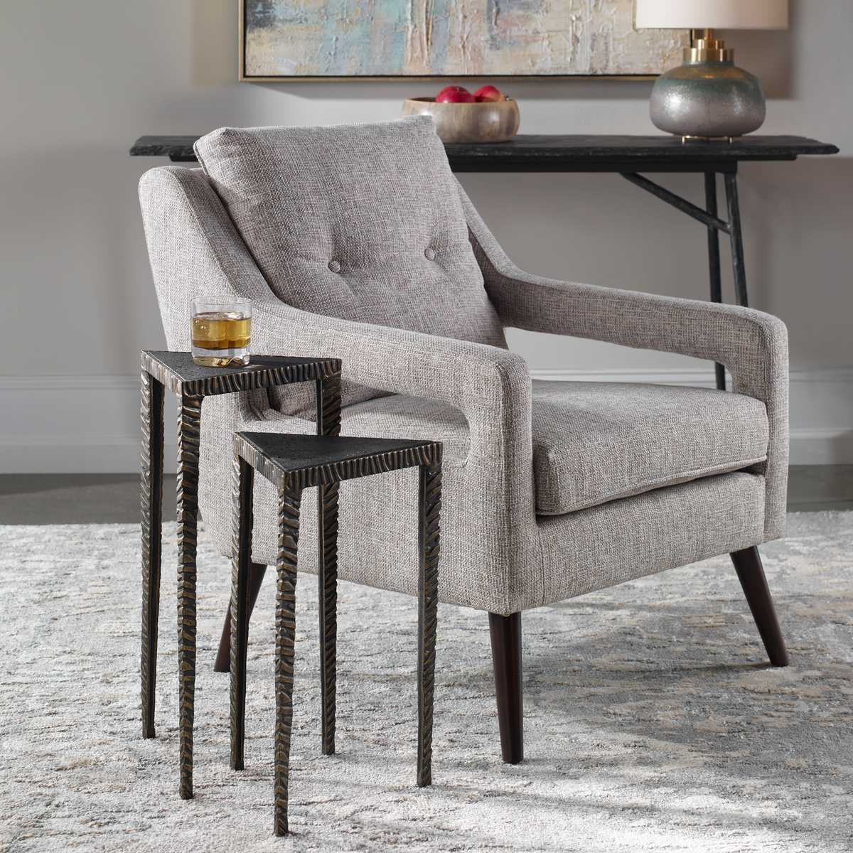 Gray armchair with two small side tables in a room setting.