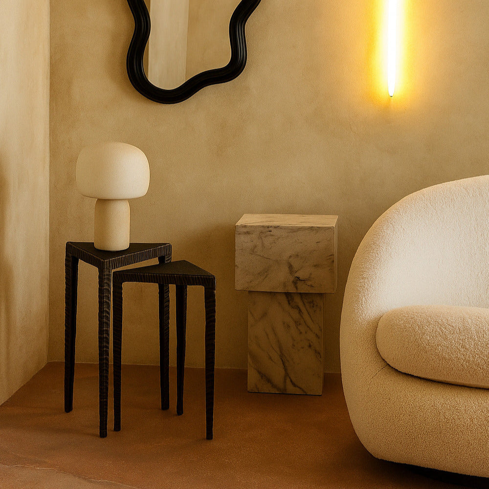 Modern interior with a black framed mirror, white lamp, and beige sofa.