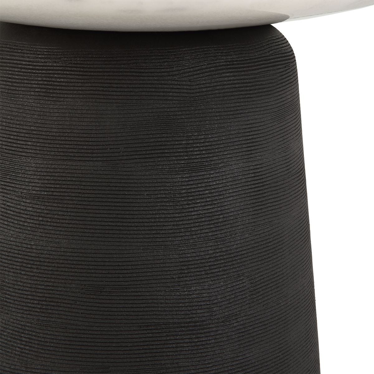 Close-up of a textured black cylindrical object with a white top.