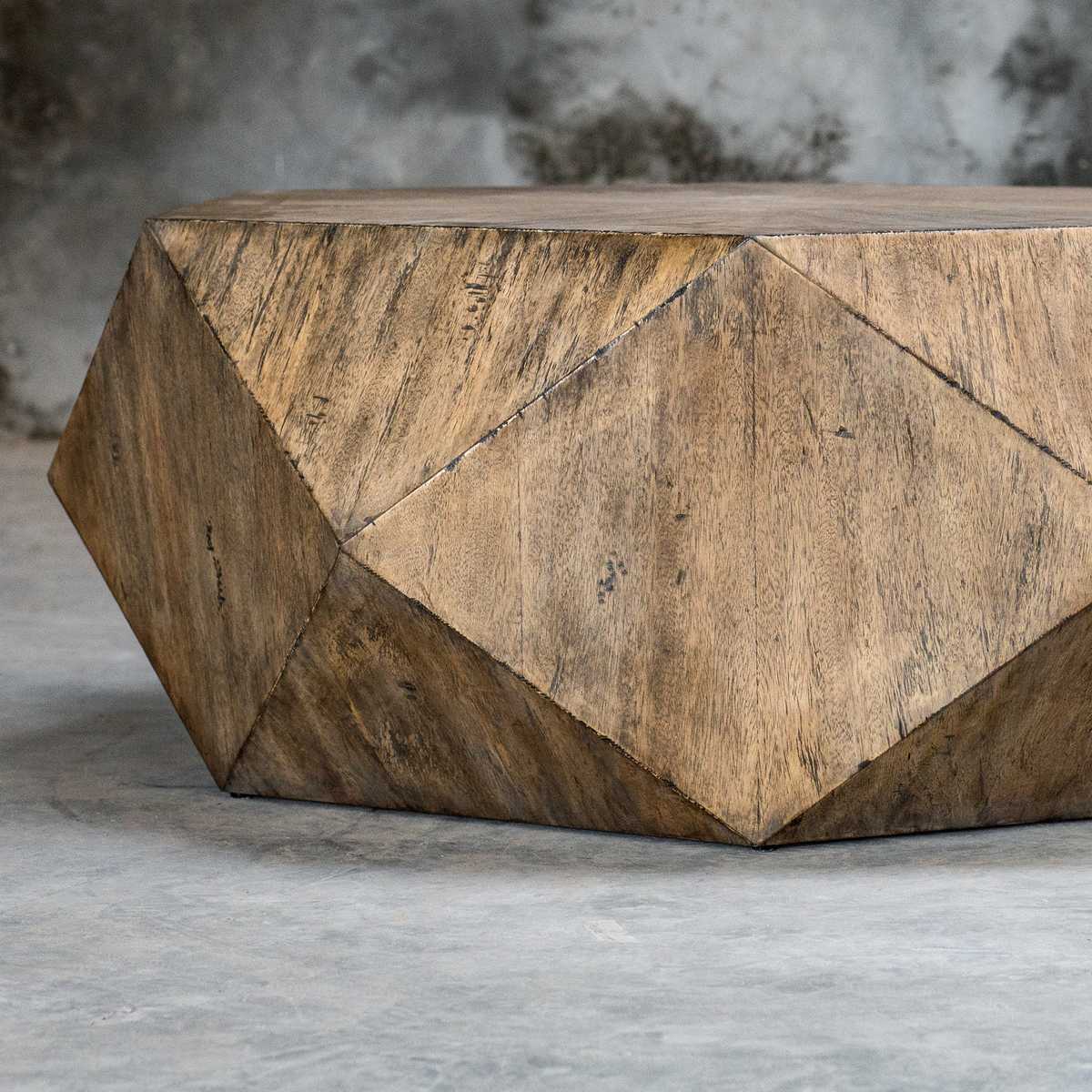 Geometric wooden coffee table with a rustic design on a gray surface.
