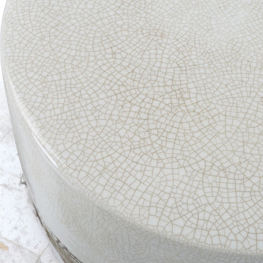 Outdoor white ceramic table with lavender on top and a coffee. Next to an outdoor wicker chair.