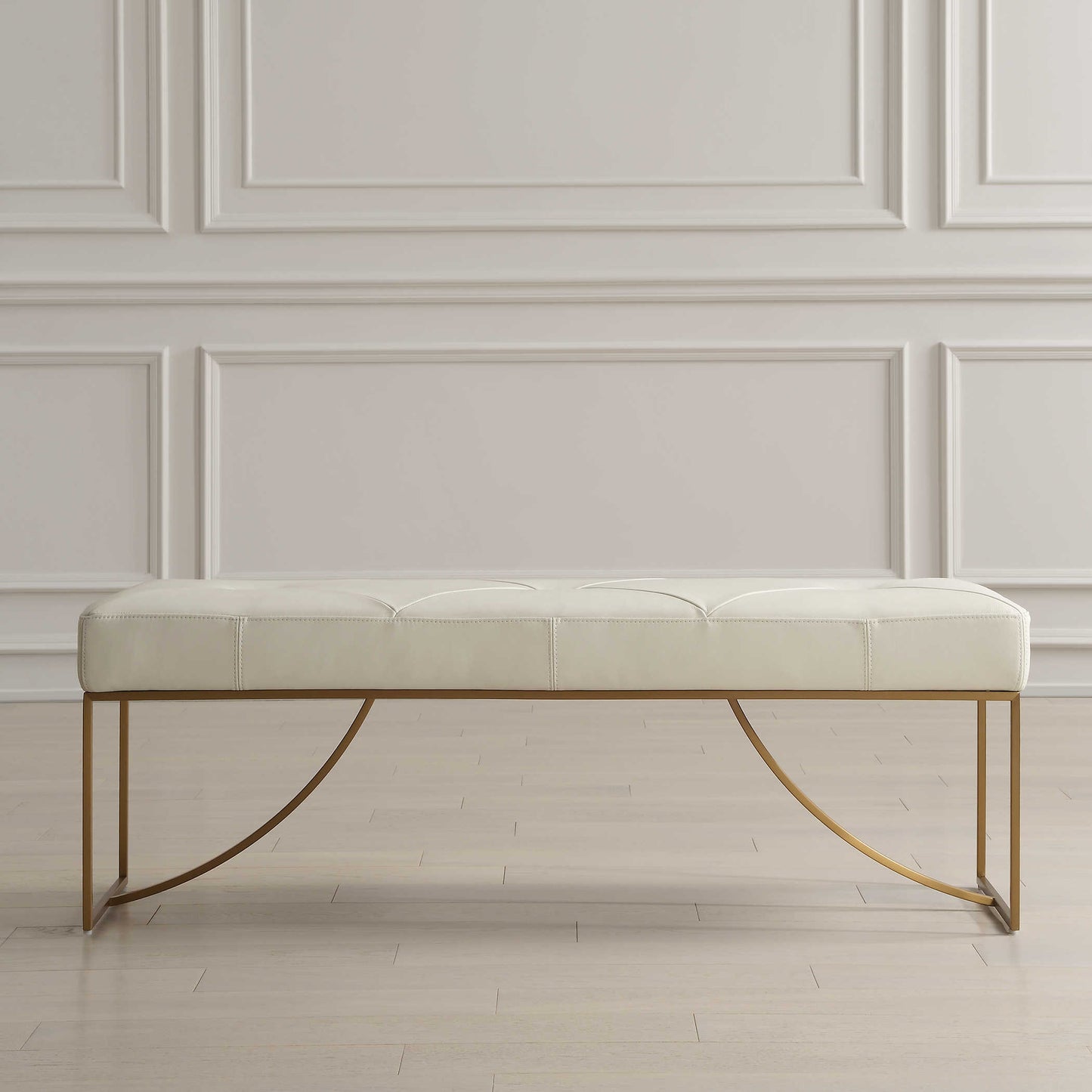 White leather bench with gold frame.
