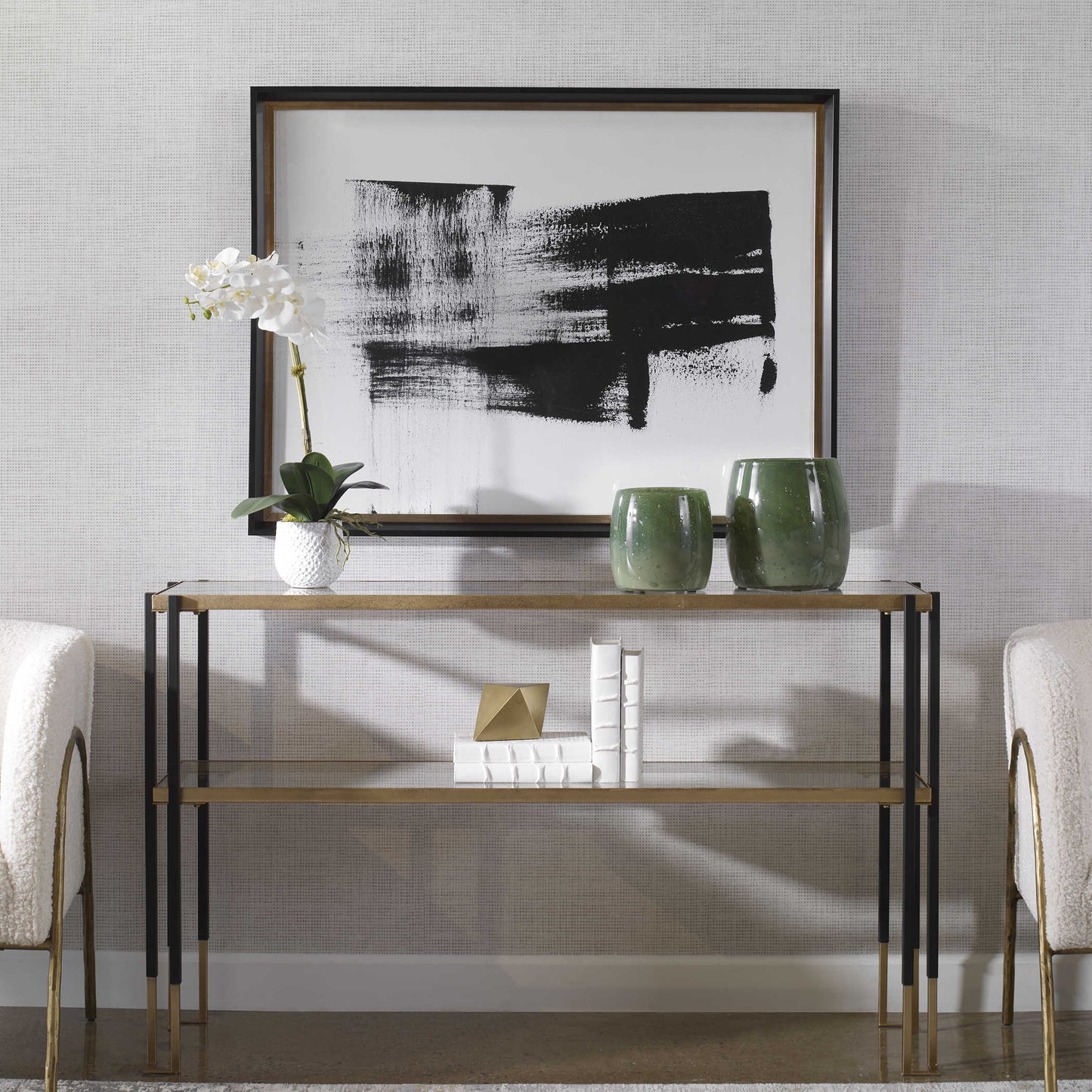 Stunning black and white running man framed print over a glass console in front of some green jars and a white orchid.