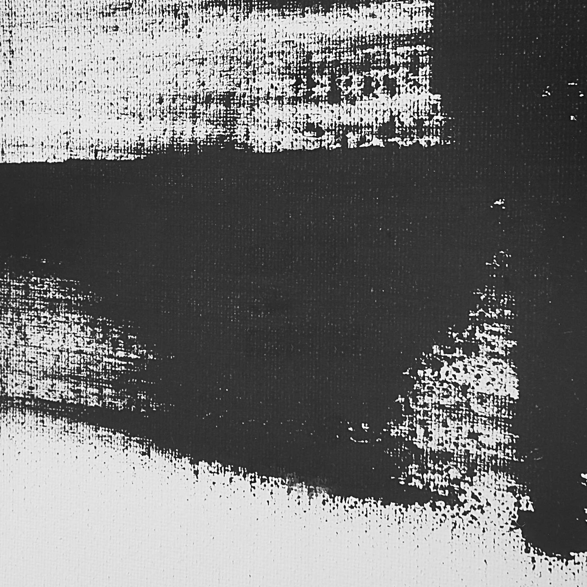 Close up shot of black paint on a white canvas.