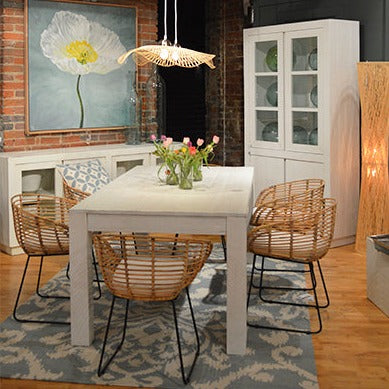 White Farmhouse Table with four chairs and a rug underneath that is blue.