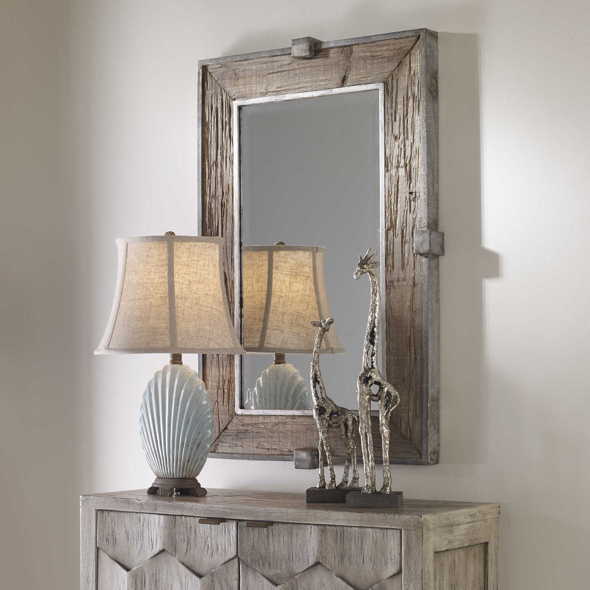 Rustic Wood Mirror over Rustic Console with Decorative Lamp and Sculptures.