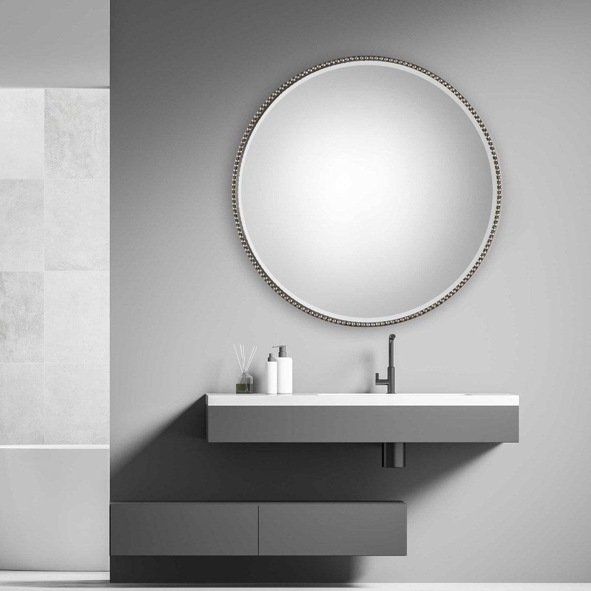 Bathroom silver round mirror above vanity.