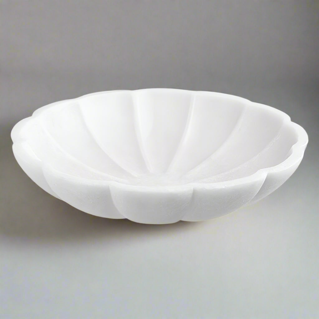 White decorative ivory bowl against gray concrete.