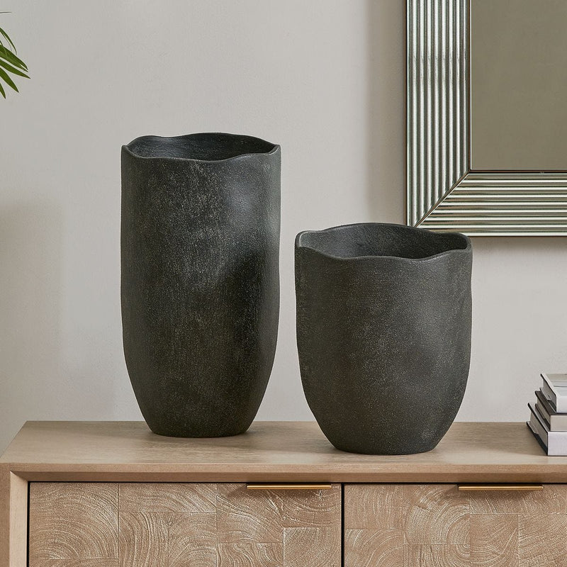 Black vases on console in entryway.