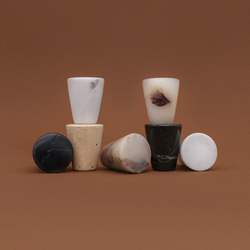 Marble Cone Knobs in Carrara, black marble, travertine, and Calacatta Viola