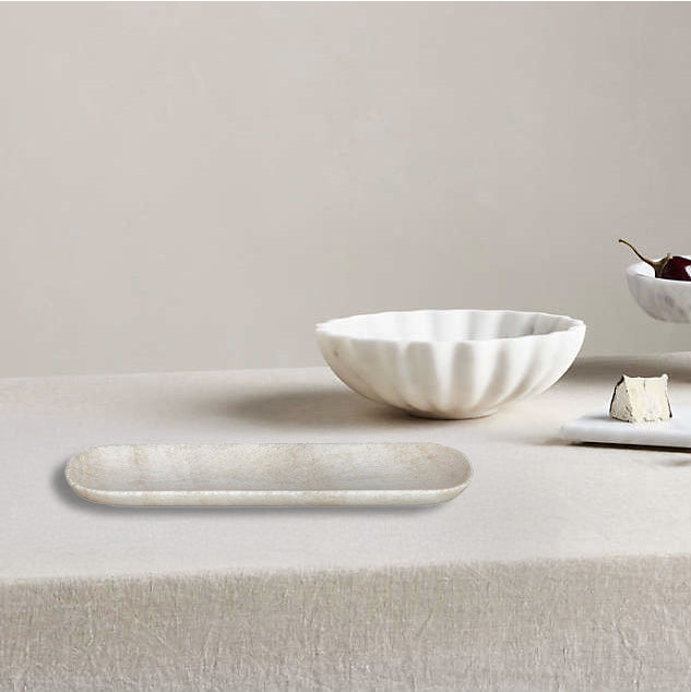 Cool stone tray on table with decorative bowl and cheese in a tablescape. 