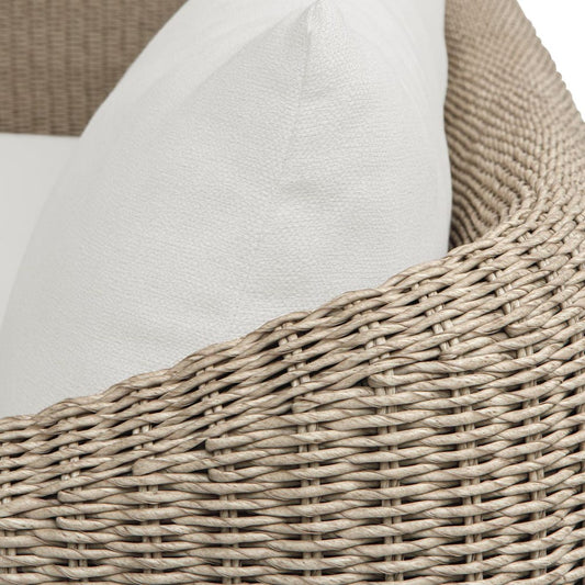 A modern two-seater sofa with cream-colored fabric cushions and textured brown woven armrests, shown in a minimalist studio setting.