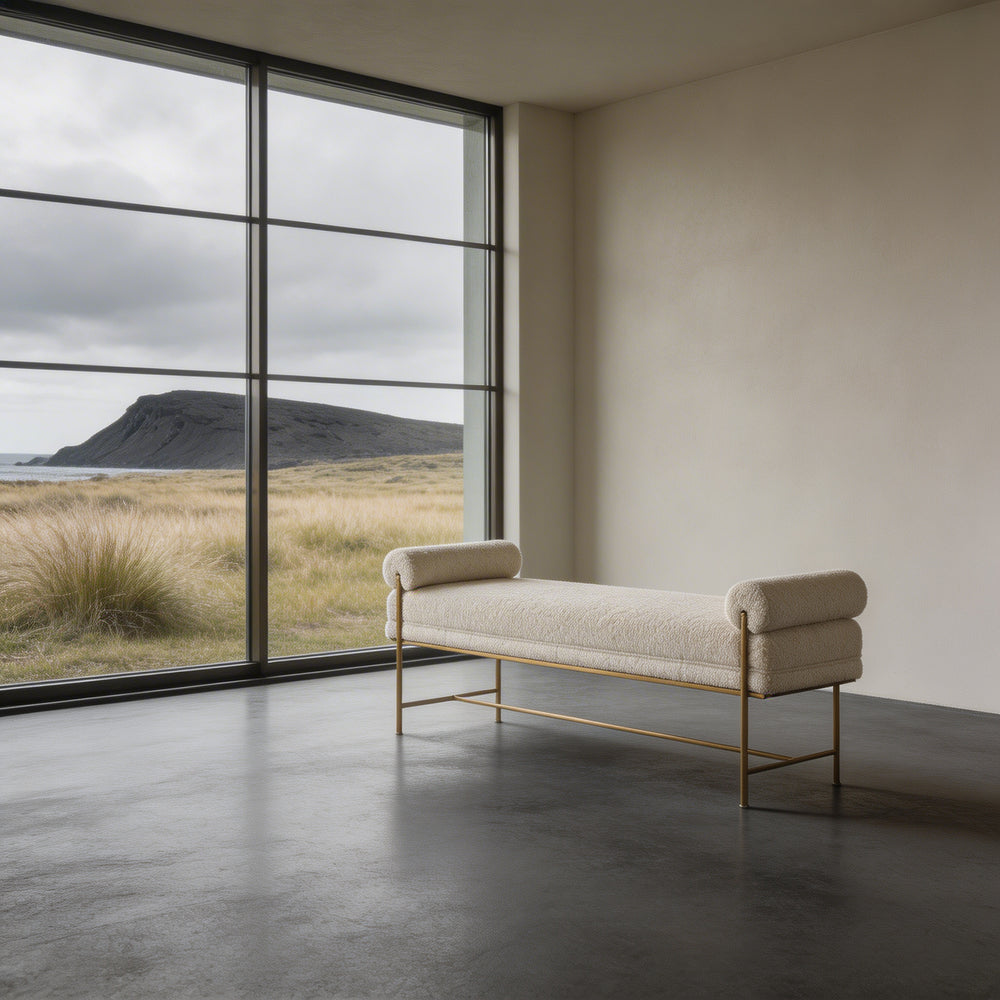 White boucle upholstered bench with gold frame on a white floor and wall