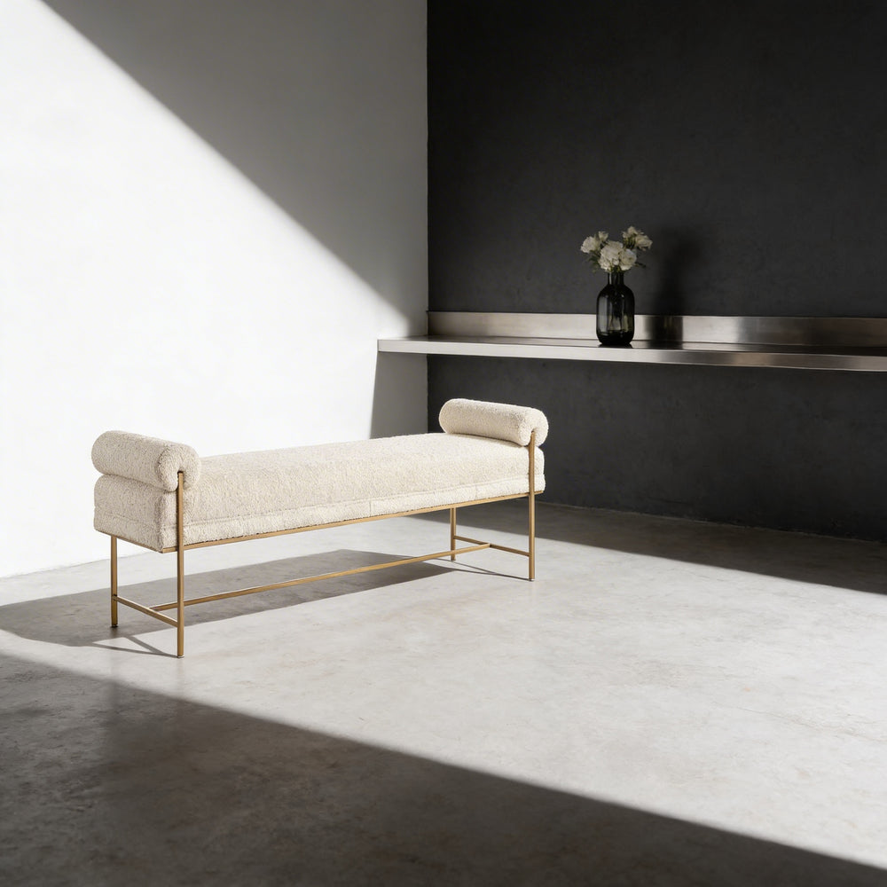 White 60 Inch bench with gold legs in a minimalistic room with a dark wall and white floor.