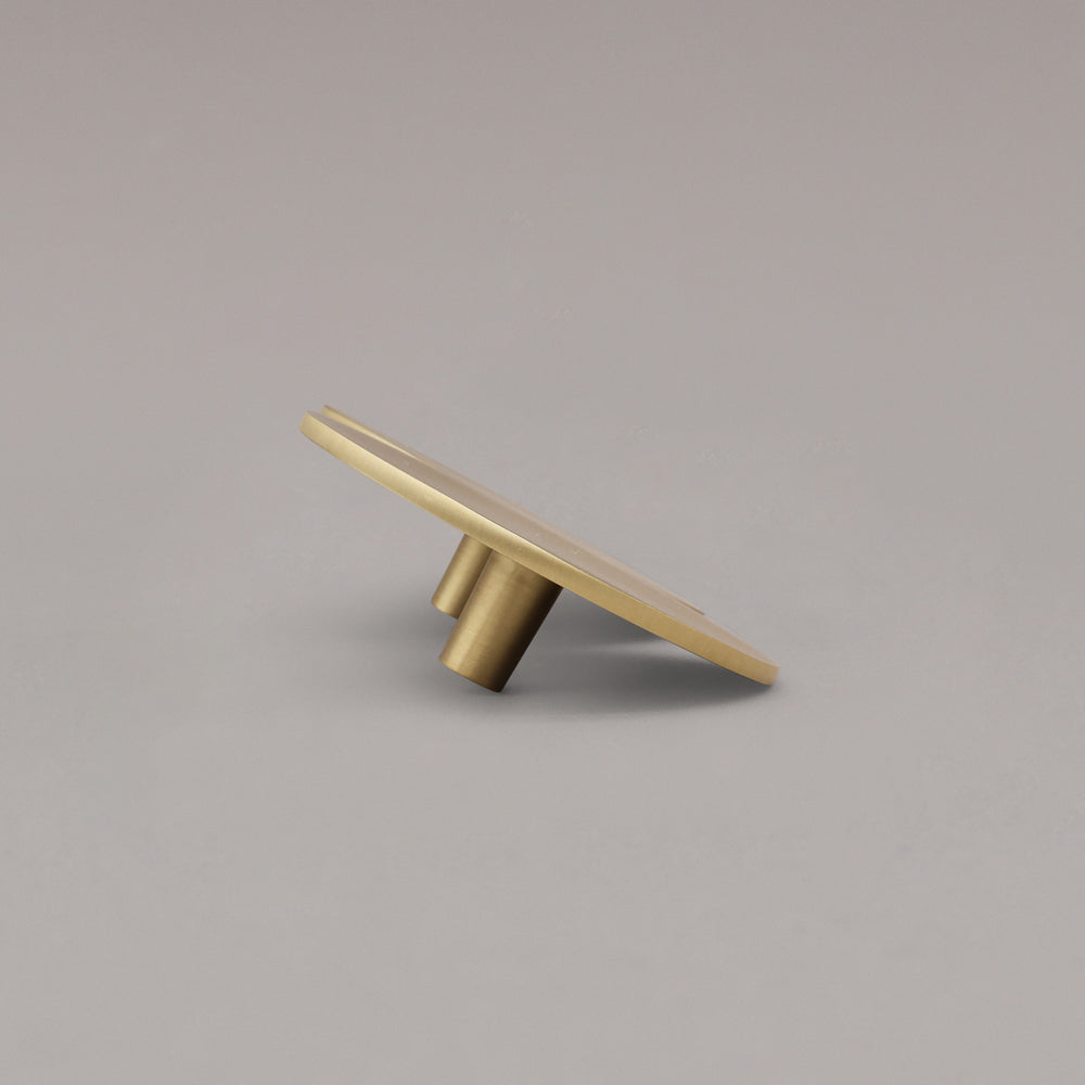 Satin brass cabinet pull on a gray background