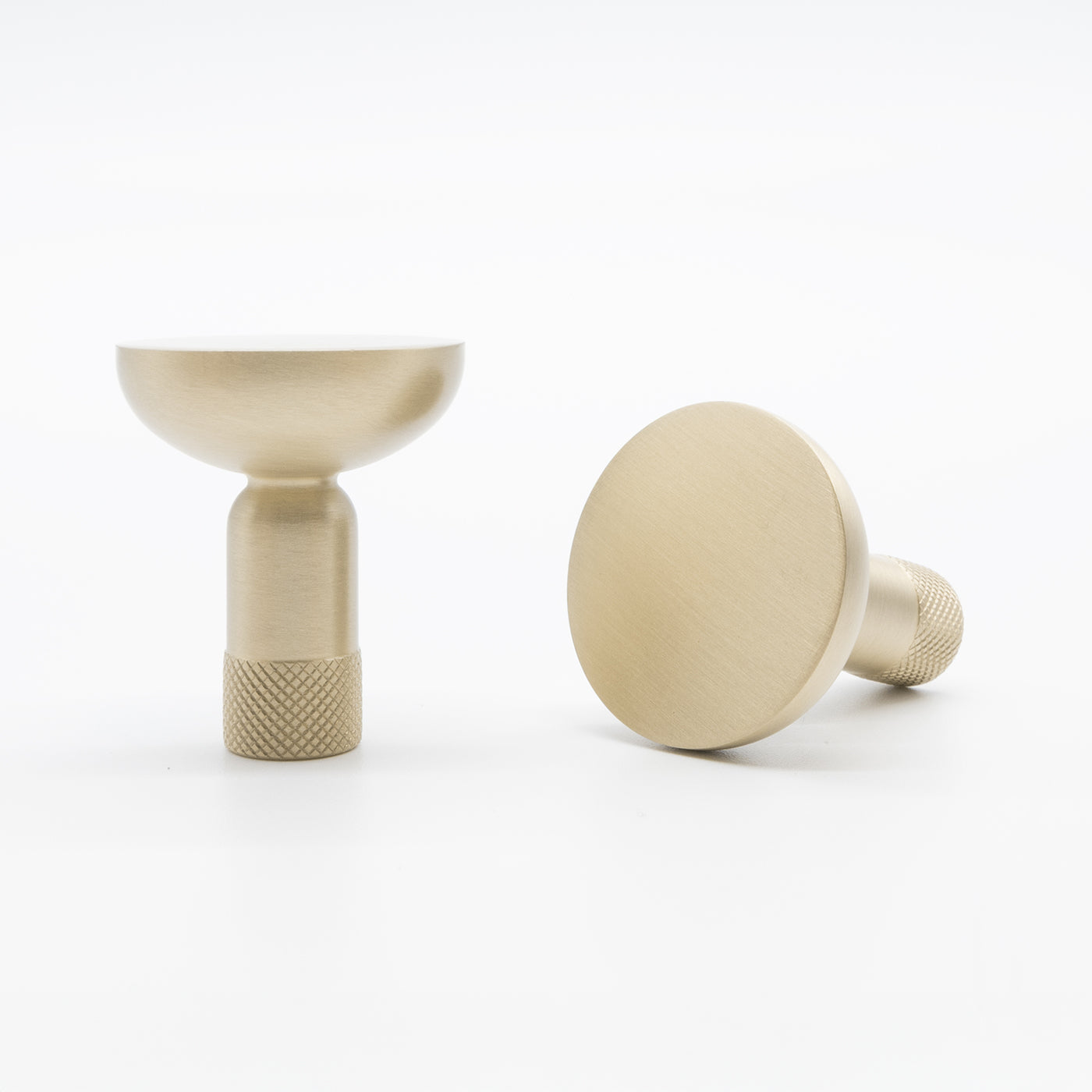 Two beige metal knobs on a white background