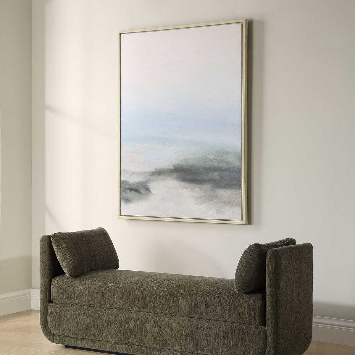Gray sofa in a room with a large abstract painting on the wall.
