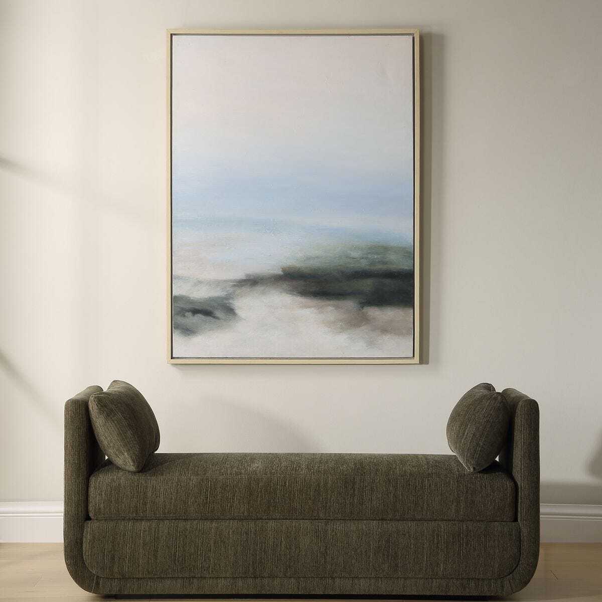 Gray sofa in a room with a large abstract painting on the wall.
