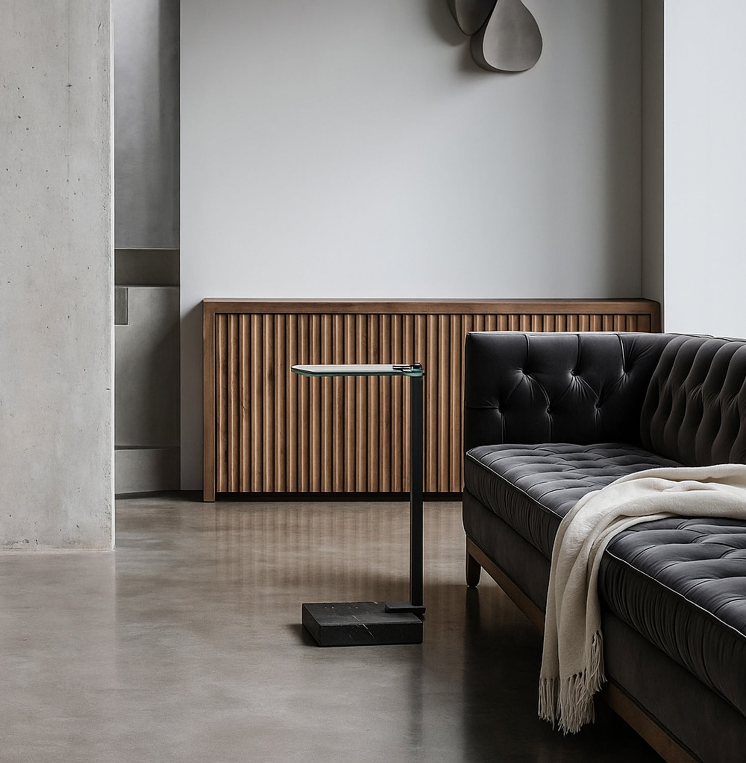 Modern living room with a gray sofa, wooden side table, and decorative wall lamp.