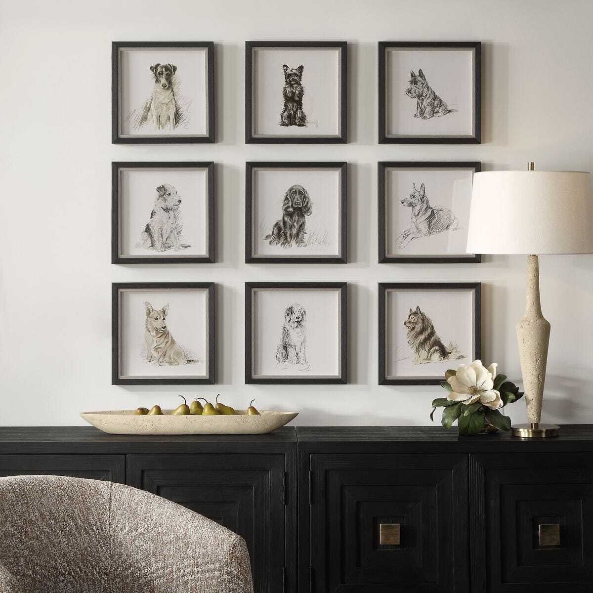 Wall with framed black and white dog prints above a dark wooden console table.