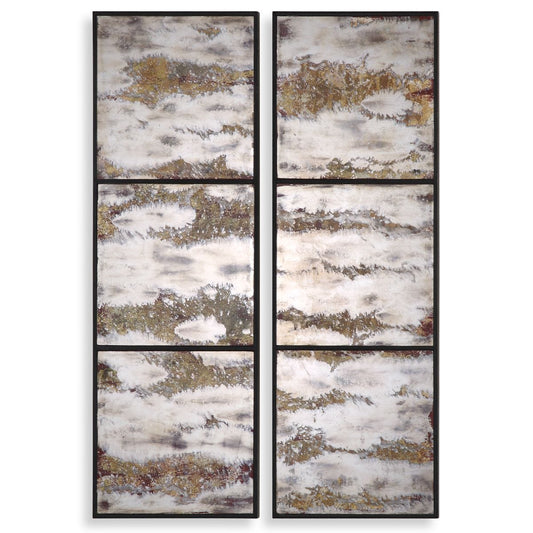 Set of four abstract wall art pieces on a gray wall above a table with decorative items.