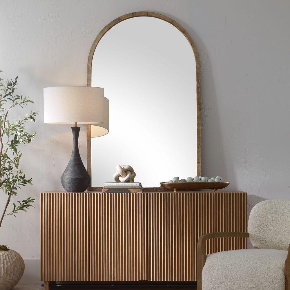 Wooden console table with decorative items, lamp, and mirror in a room setting.