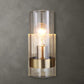 Bathroom wall sconce with aged brass on concrete wall.