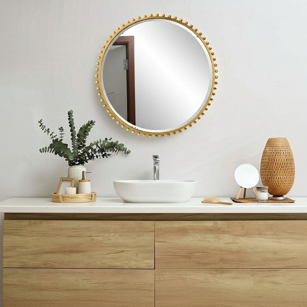 Bathroom vanity with round mirror, plant, and decorative items on a light gray wall.