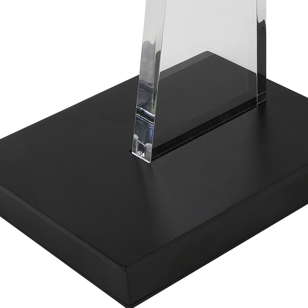Clear glass object on a black base with a white background
