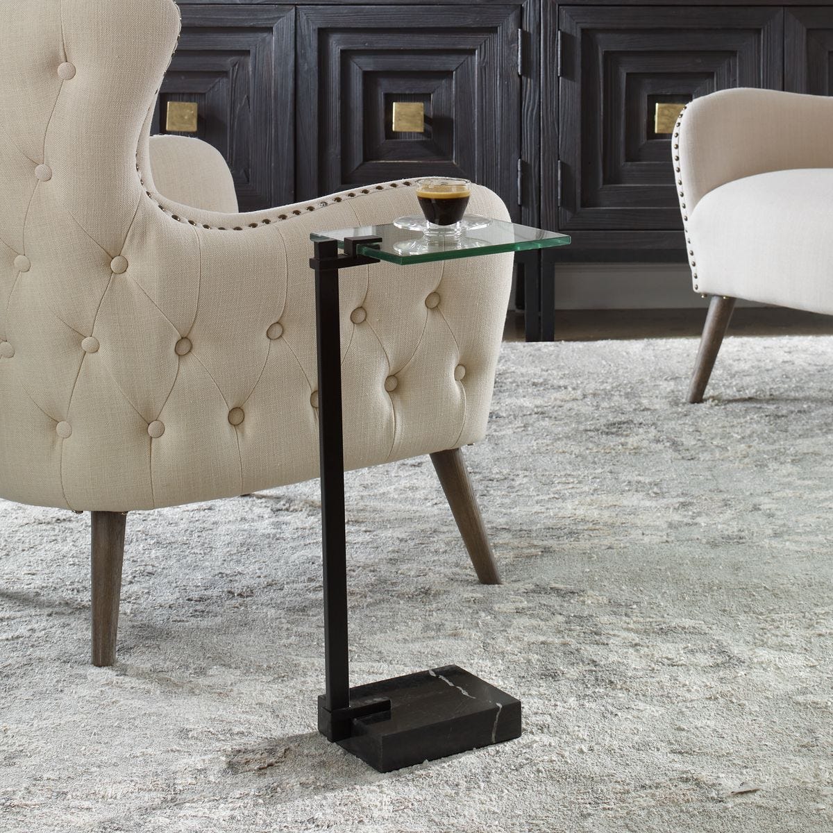 Beige armchair with a glass side table in a stylish room.