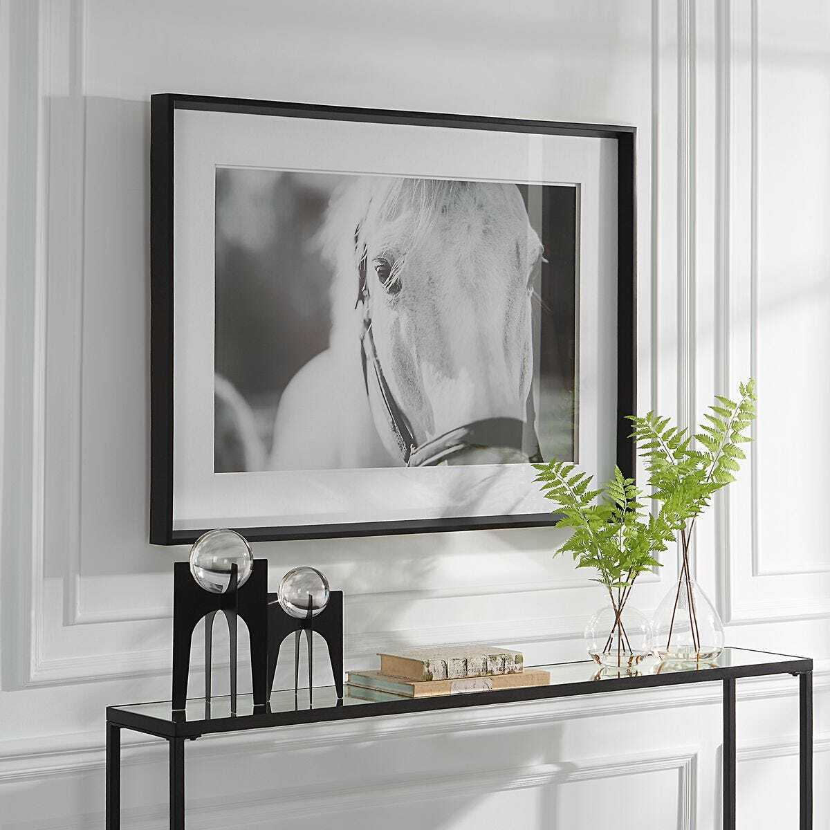 Black and white horse art above console.