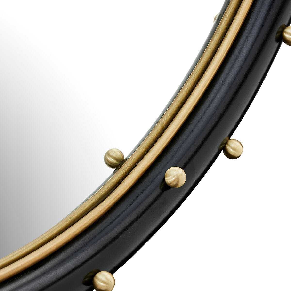 Round mirror with a gold frame and decorative studs on a white background