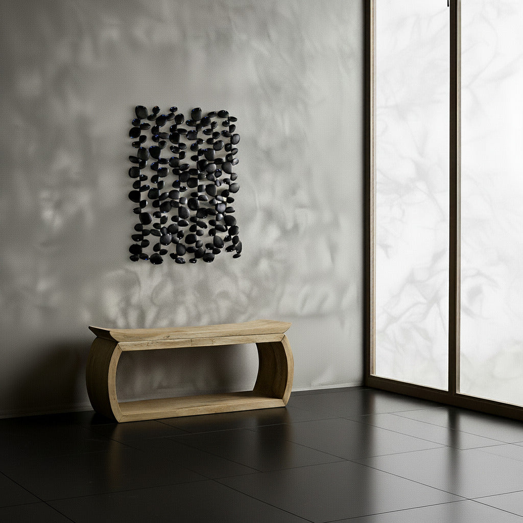 Modern interior with a wooden bench and decorative black metal wall art against a textured wall.