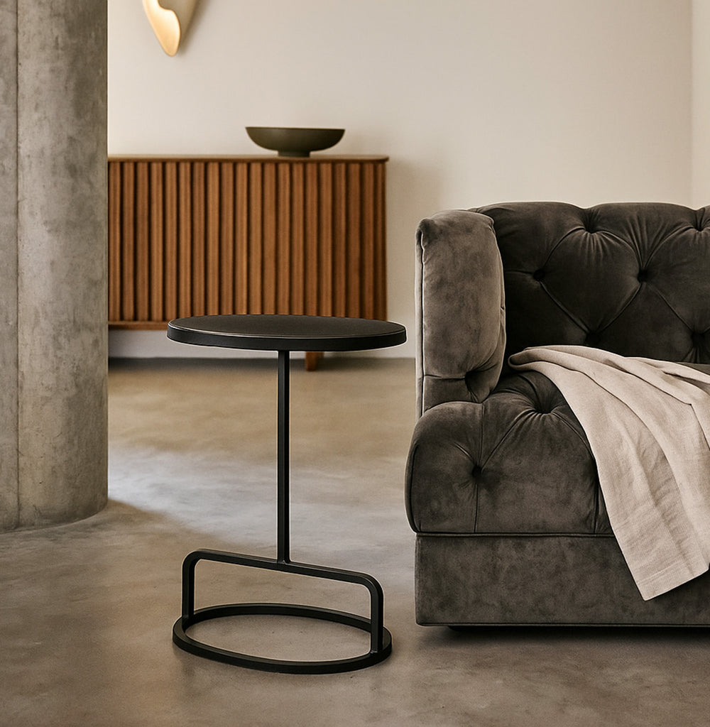 Modern living room with a gray sofa, black side table, and wooden cabinet.