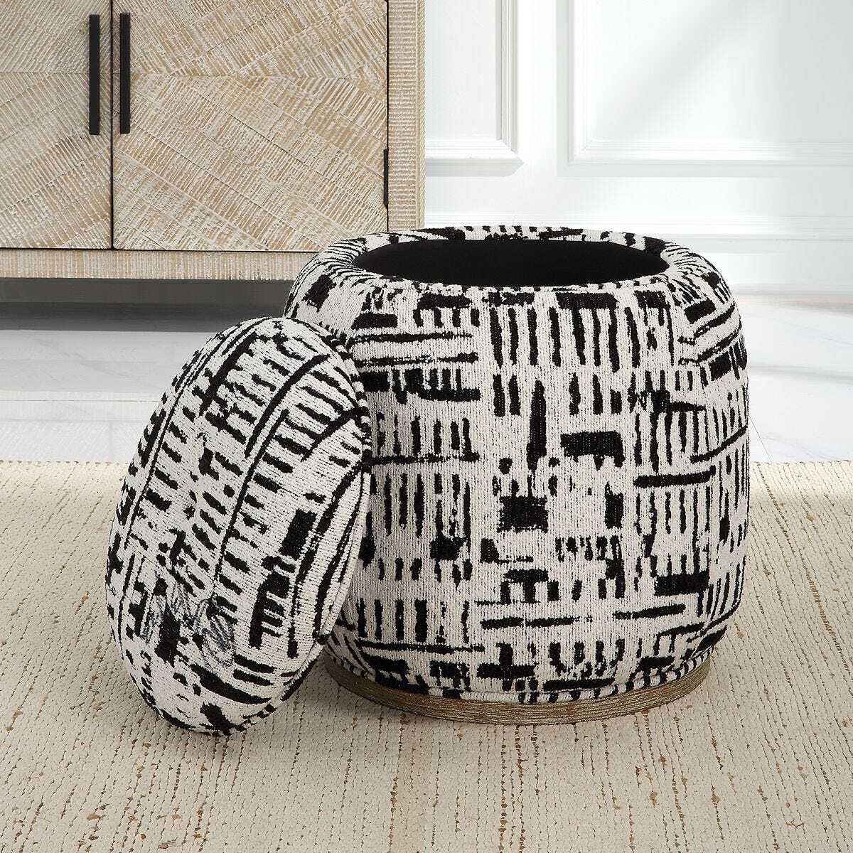 Black and white patterned ottoman on a beige carpet