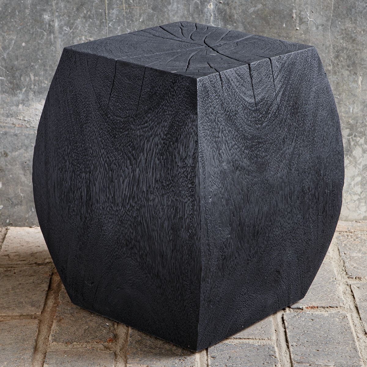 Black stone cube on a textured stone surface