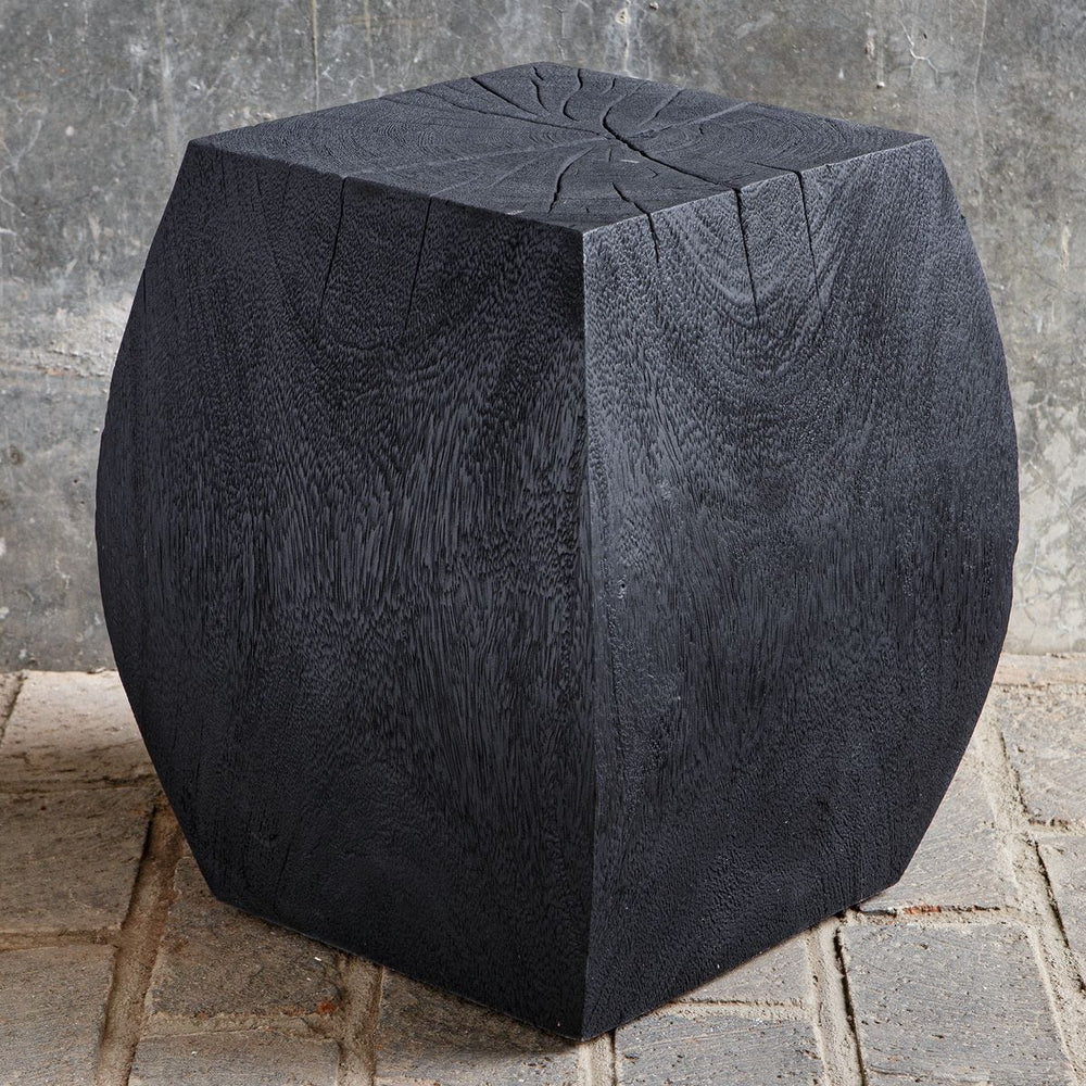 Black stone cube on a textured stone surface