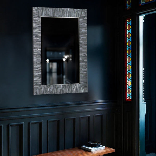 Blue and silver wall mirror hung in a navy entryway with a museum bench,