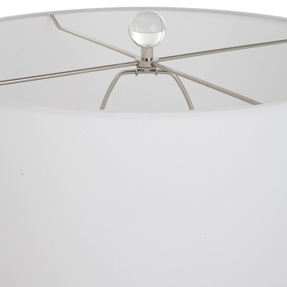 Close-up of a lamp with a white shade and metal fixture on a white background