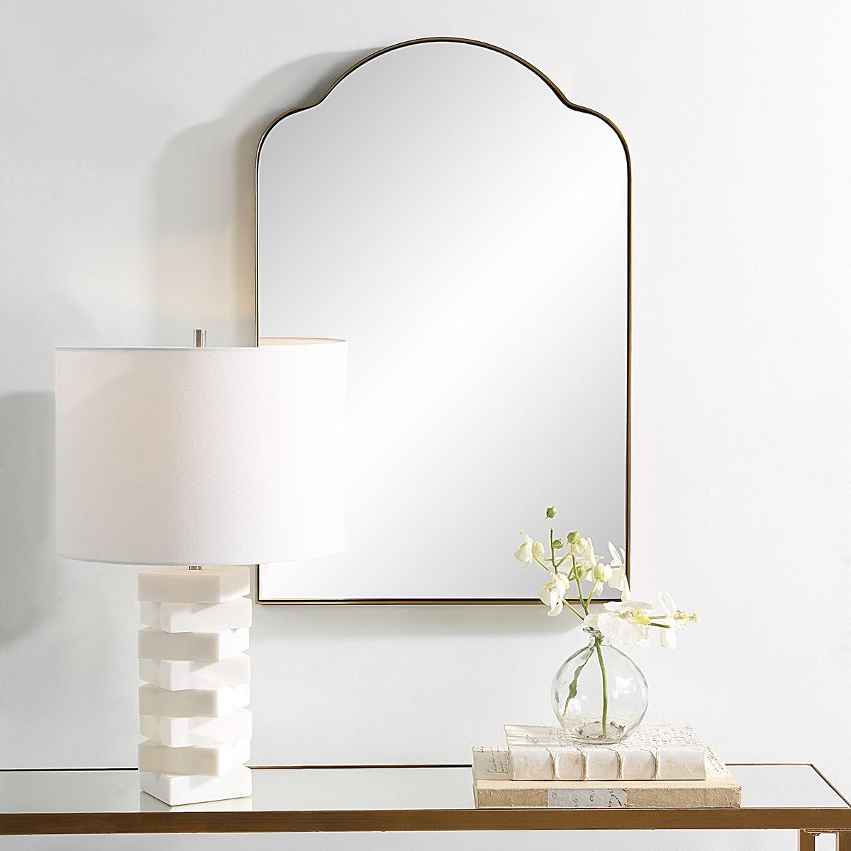 Brass arched gold mirror above console.