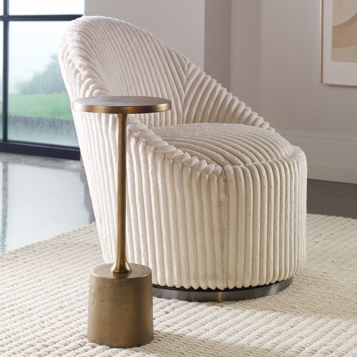 Brass table in a modern living room with white decorative chair.