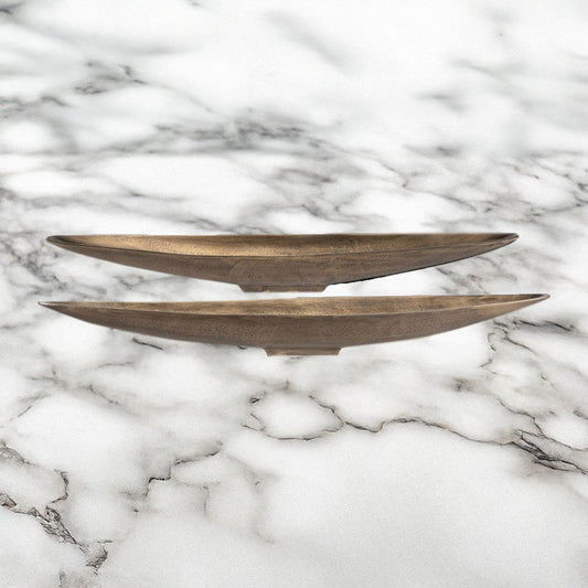 Two brass trays on marble kitchen counter.