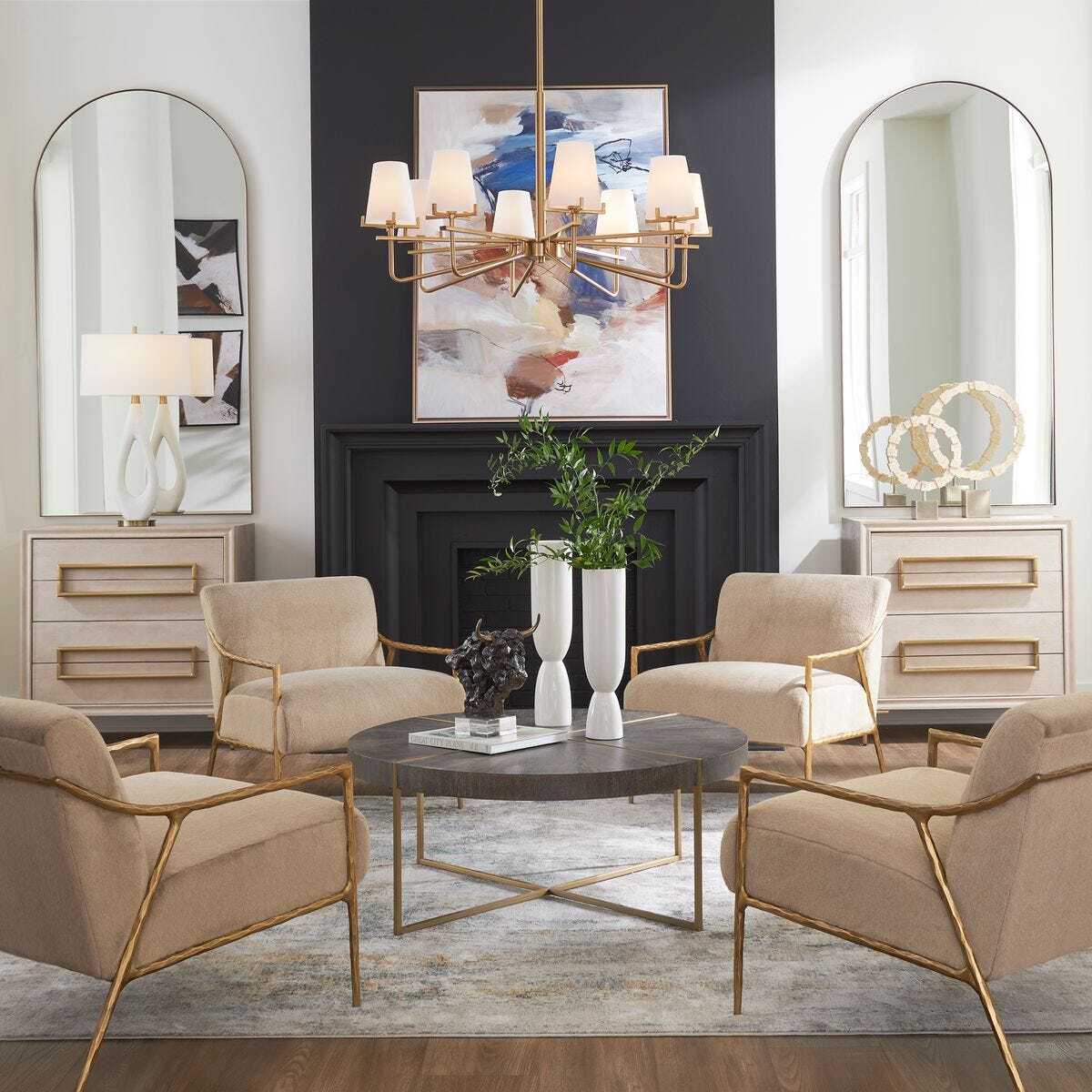 Modern living room with beige armchairs, a round coffee table, and decorative elements.
