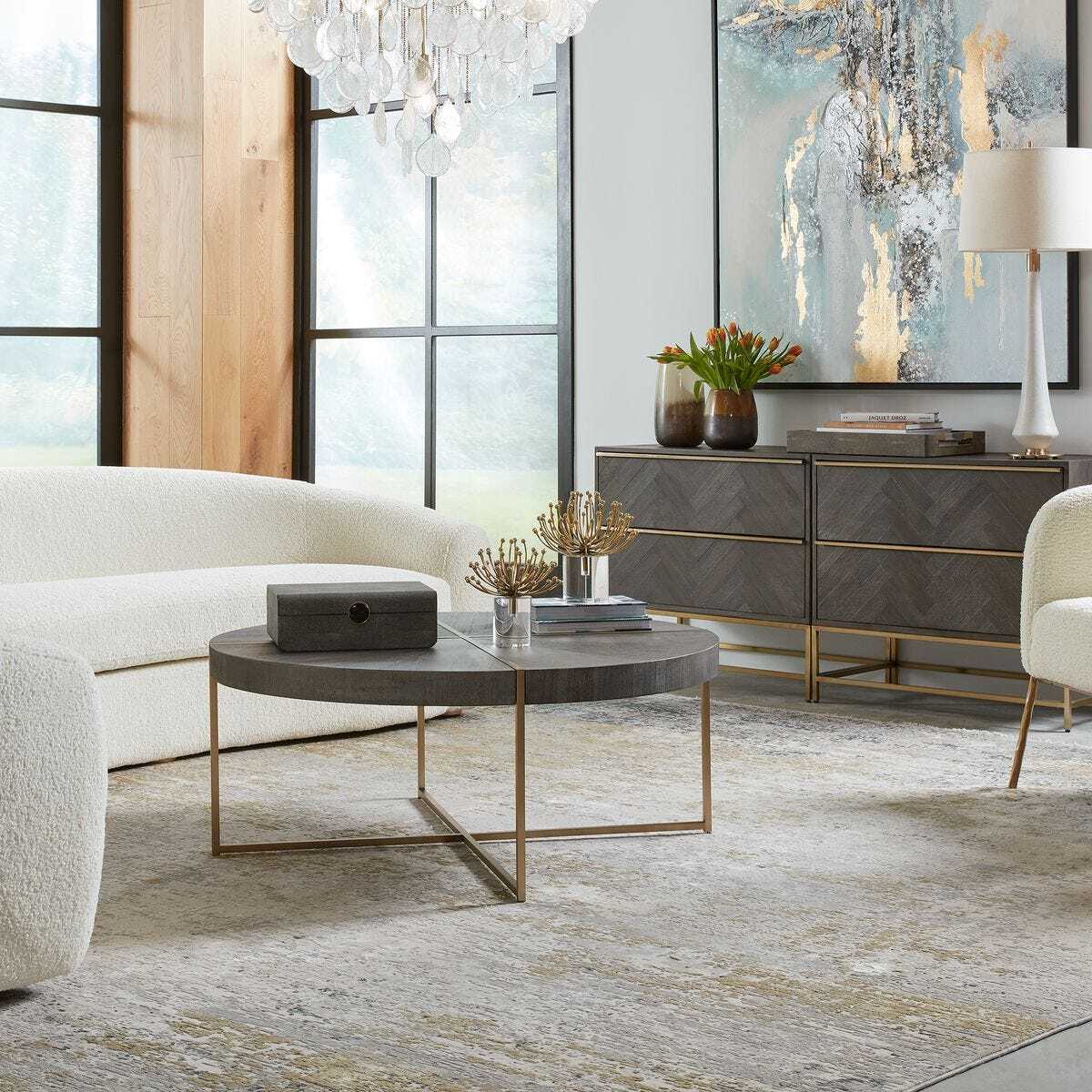 Modern living room with a round coffee table, white sofa, and decorative elements.