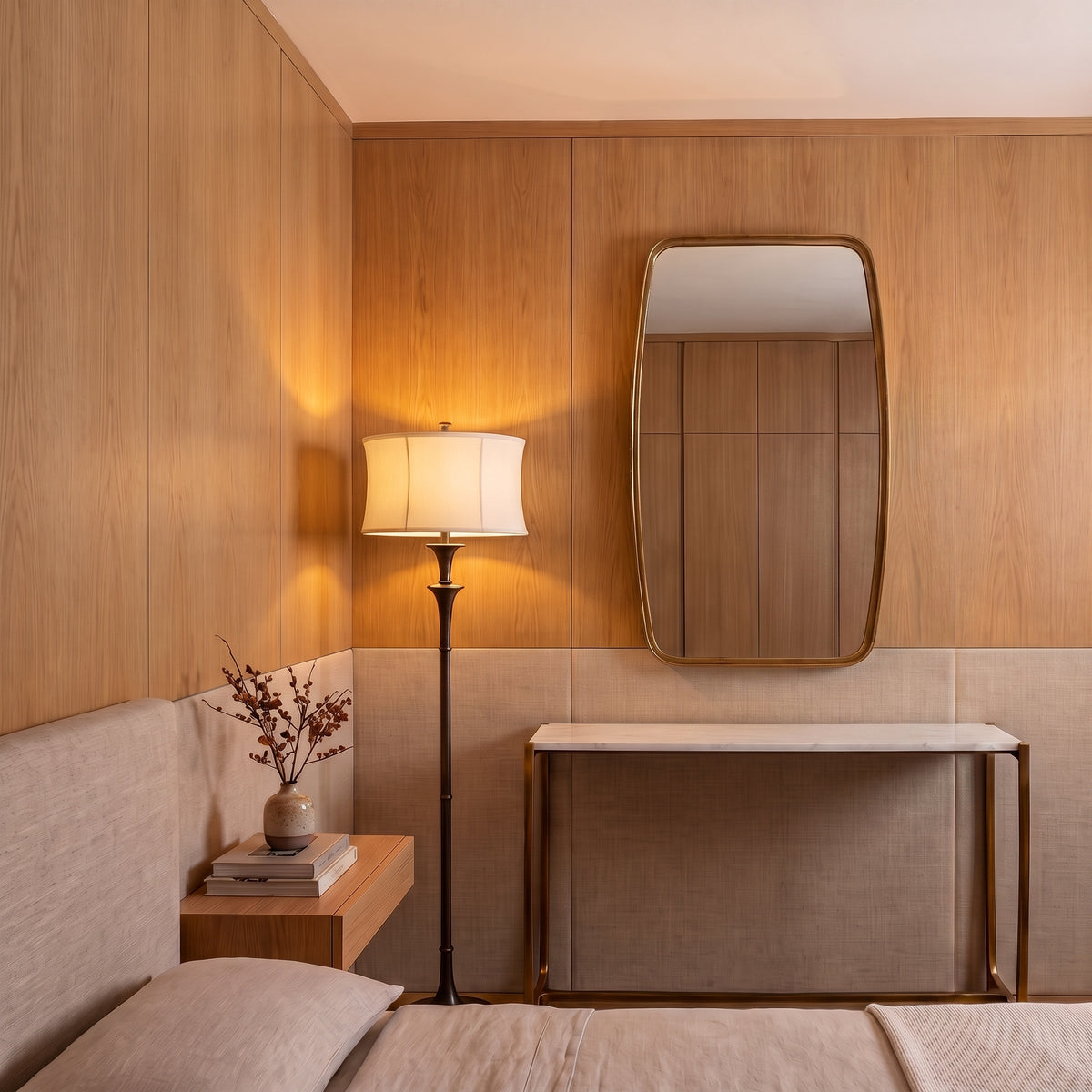 A modern bedroom interior with warm wood-paneled walls, a floor lamp, a wall mirror, a console table, and part of a bed with beige bedding in the foreground.