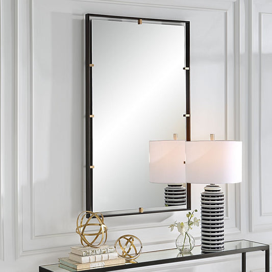 White rocking chairs in living room with two-tone brass and black vertical mirror. Modern room with side table. 